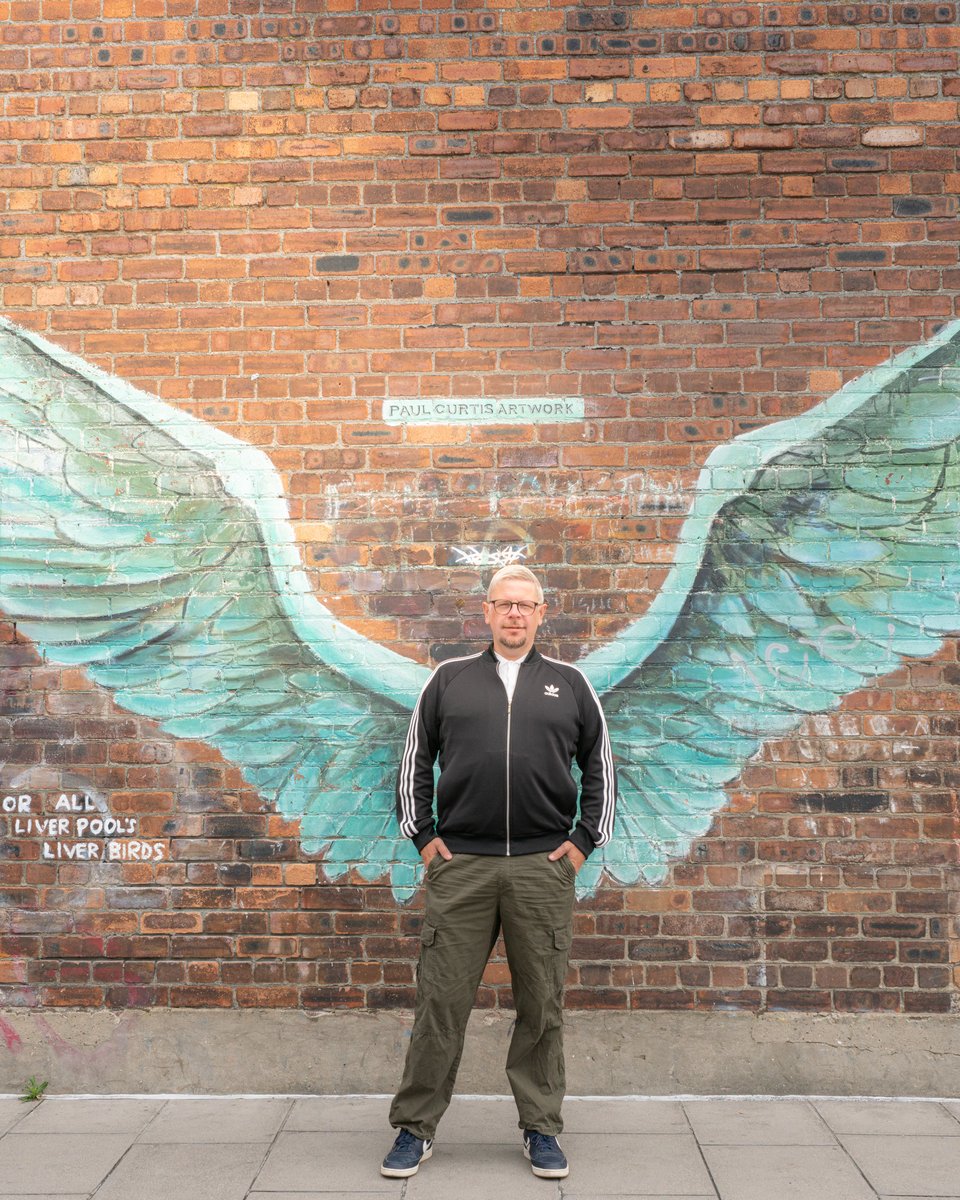 Scott McLellan in front of the Liverpool angel wings mural